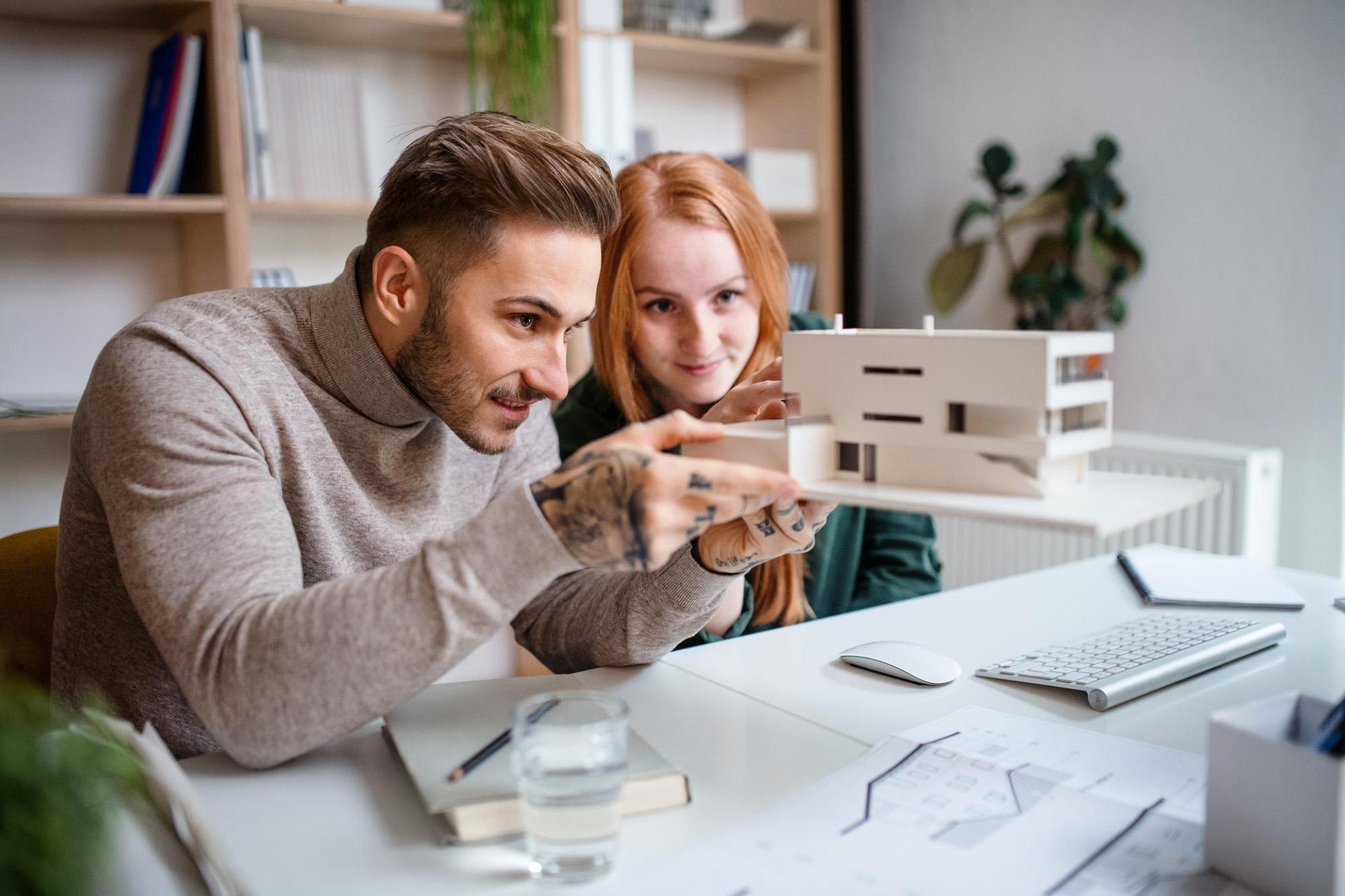 Photo d’un couple qui regarde la maquette d’un projet immobilier